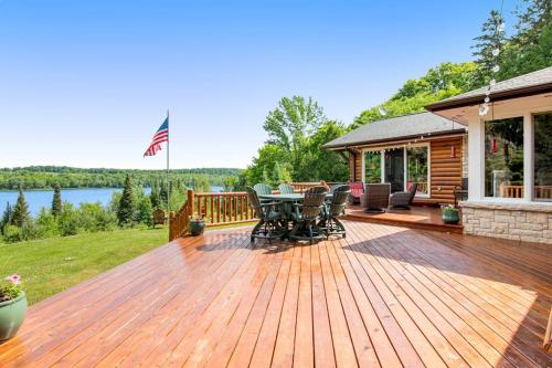 a wooden deck with a table and chairs on a house at Bayside Secret in Phelps
