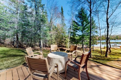 a wooden deck with chairs and a table on it at Blissful St Germain Retreat in Saint Germain
