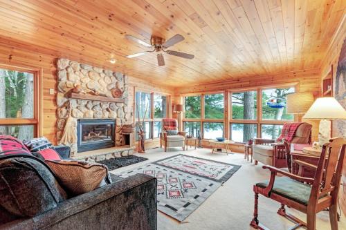 a living room with a fireplace and a stone wall at Hotter's Cabin in Eagle River