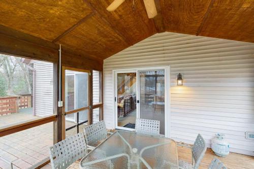 a patio with a glass table and chairs on a porch at Nekoosa Holiday in New Rome