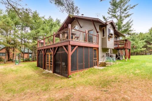 a large house with a deck on top of a yard at One Acre Wood in Eagle River