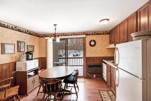 a kitchen with a table and a white refrigerator at Cleerwood Village #252 in Eagle River