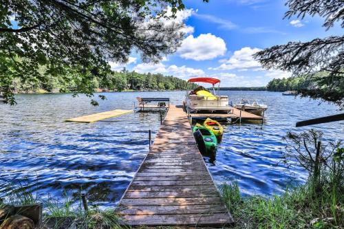 a dock with a boat on a lake at West Bay Pines in Saint Germain