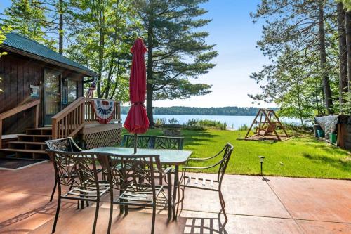 a patio with a table and chairs and an umbrella at Catfish Cottage A in Eagle River