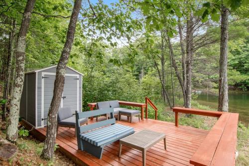 a wooden deck with a bench and a shed at Cove View in Minocqua