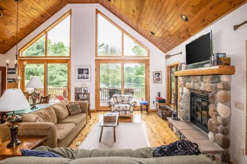 a living room with a stone fireplace with a tv at Northwoods Getaway in Arbor Vitae