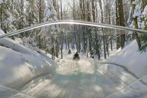 a person is skiing down a snow covered trail at Shady Lane Lodge in Eagle River
