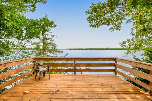 a bench sitting on a wooden boardwalk next to a lake at Ashton House in Phelps