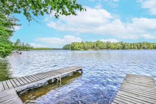 a dock on a lake with trees in the background at The Lazy Bear in Saint Germain