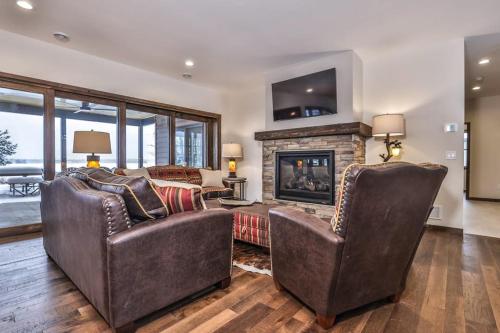 a living room with two chairs and a fireplace at Endless Summer in Sayner