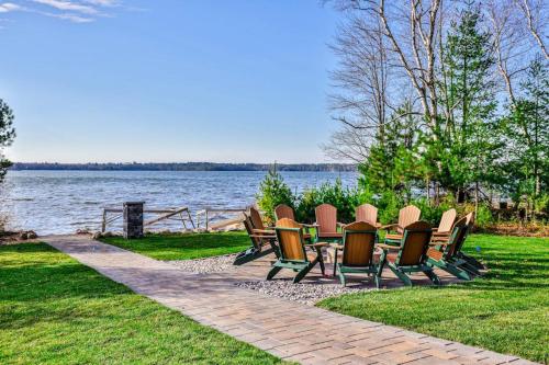 a group of chairs sitting on the grass near the water at Endless Summer in Sayner