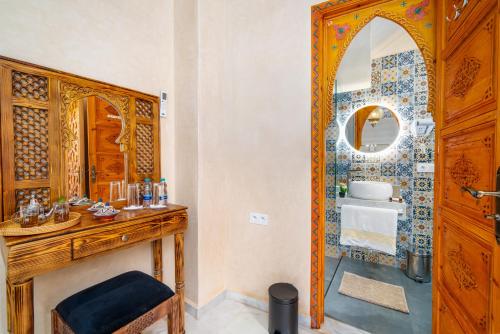 a bathroom with a wooden vanity and a mirror at Riad Nadalinn in Marrakesh