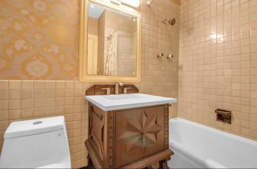 a bathroom with a sink and a tub and a toilet at The Mayfair Castle in Buffalo