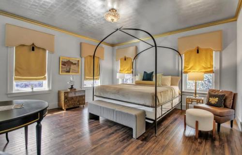 a bedroom with a bed and a table and a chair at The Mayfair Castle in Buffalo