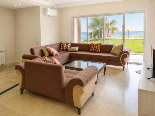 a living room with two couches and a table at Seaside Mediterranean Duplex in Kelibia