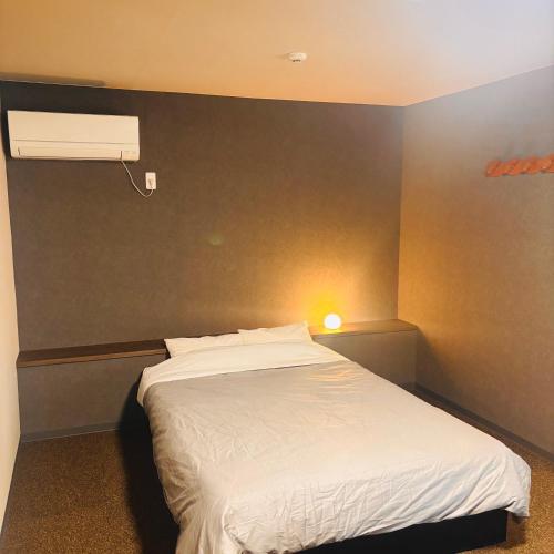 a bedroom with a white bed and a white fan at ホテル　ロマン in Koshimizu-shigai