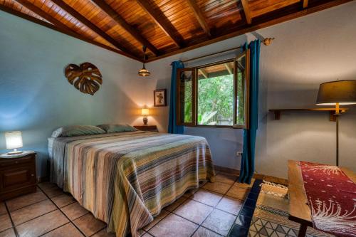 a bedroom with a bed and a window at Casa Selva in Dominicalito
