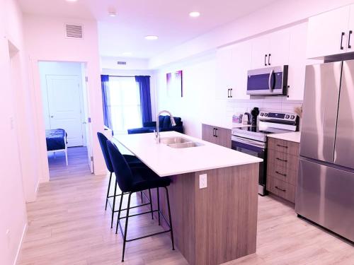 una cucina con un lavello e un bancone con sgabelli di Condo in Secord a Edmonton