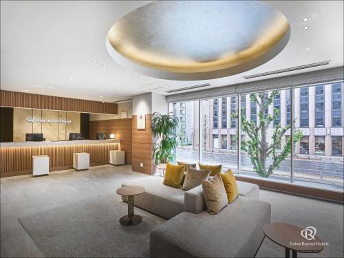 a living room with a couch and a large window at Daiwa Roynet Hotel Nagoya Eki Mae in Nagoya