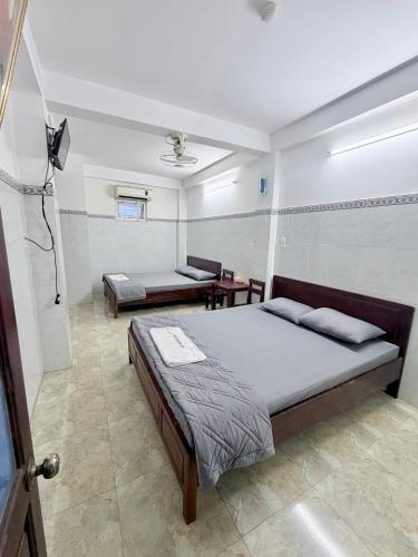 a bedroom with a large bed and a bathroom at Nhà Nghỉ Hoa Lan2 in Buon Ma Thuot