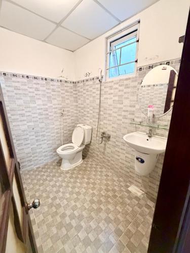 a bathroom with a toilet and a sink at Nhà Nghỉ Hoa Lan2 in Buon Ma Thuot