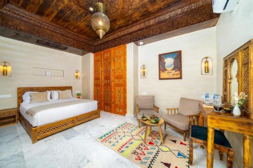 a bedroom with a bed and a desk in a room at Riad Nadalinn in Marrakesh