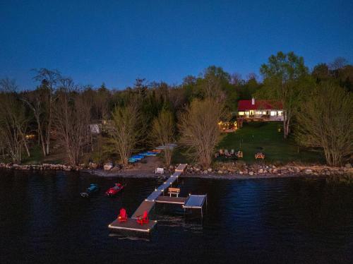 a dock with boats in the water with a house at Chalet des Oiseaux Bleus, Spa, Lac in Saint-Gérard