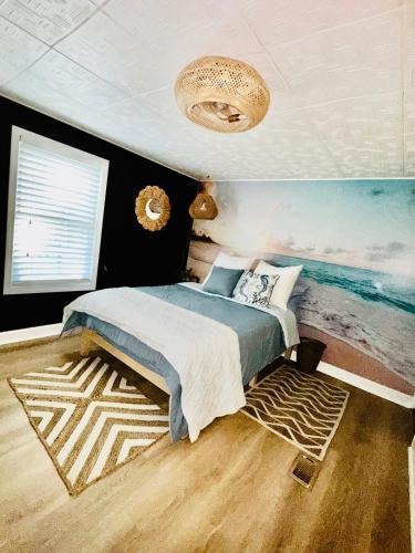 a bedroom with a bed and a painting of the ocean at The Get Away Haven in Stockbridge