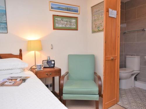 a bedroom with a bed and a chair and a toilet at 3 Bed in Polruan oc-pc052 in Polruan