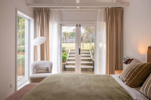 a bedroom with a bed and a chair and a window at Wondervale in Burrawang