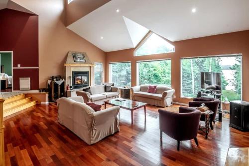 a living room filled with furniture and a fireplace at Le Chaleureux du Lac Blanc - Nominingue in Nominingue