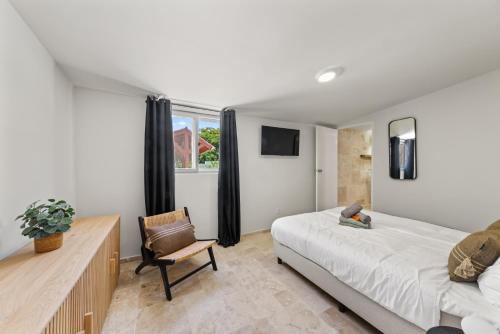 a bedroom with a bed and a desk and a chair at Caribe CBW in Willemstad
