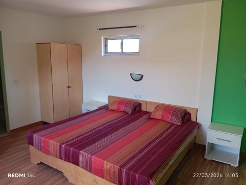 a bedroom with a bed with purple sheets and a window at Casa Chez Zoe in Salamansa