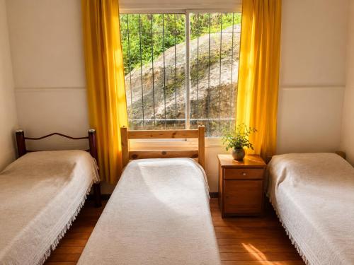 two beds in a room with a window at Ohana Apartments (solo familias) in Villa Carlos Paz