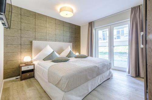 a bedroom with a bed and a large window at Großer Strandkorb - Stilvolles Ferienapartment in der Alten Seefahrtsschule in Wustrow