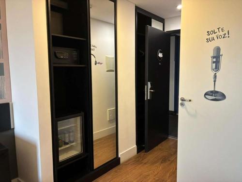 a room with a glass door with a mirror at ibis Styles Taubate in Taubaté