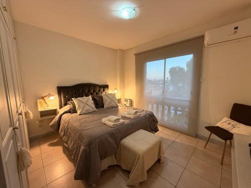 a bedroom with a bed and a large window at En el Corazón de la Quinta. in Villa Marini