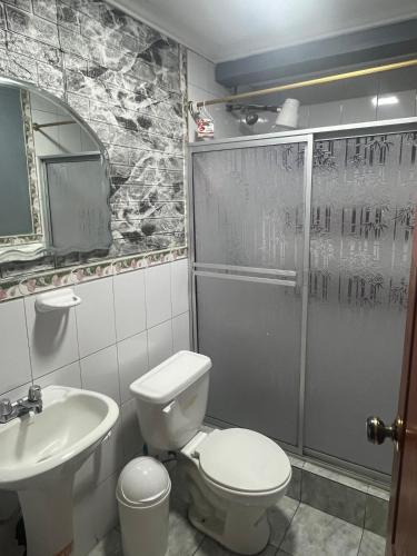 ein Badezimmer mit Toilette, Waschbecken und Dusche in der Unterkunft Departamentos en Cuenca in Cuenca