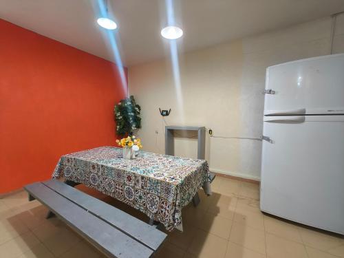a kitchen with a table and a refrigerator at Hostal Ciudad de México - Habitaciones privadas con Wi-Fi en el centro histórico in Mexico City