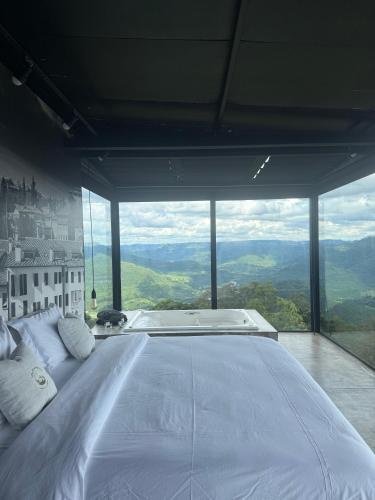 a large bed in a room with a large window at Casas na montanha - Villa Montegrappa in Caxias do Sul