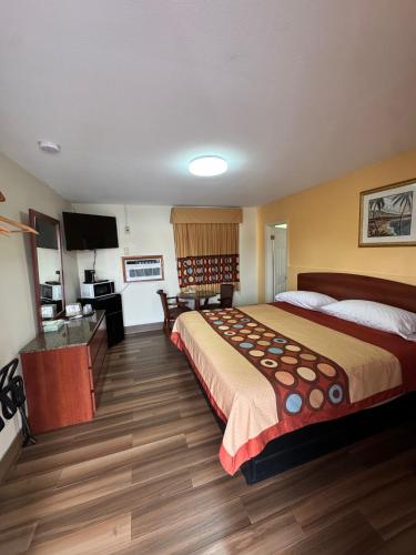 a hotel room with a large bed and a television at Snowbird Motel in Bristol