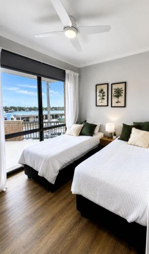 two beds in a bedroom with a balcony at Coastal Bliss in Lemon Tree Passage