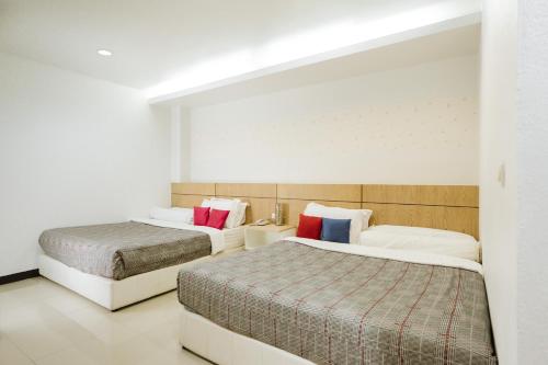 two beds in a hotel room with two beds at The Rama Hotel in Chiang Rai