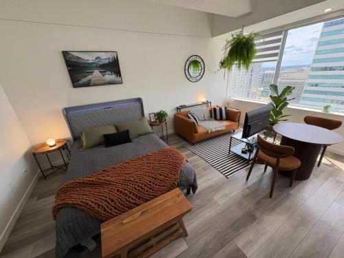 a bedroom with a bed and a living room at Boho Studio Downtown Rogers Views Heated Parking in Edmonton