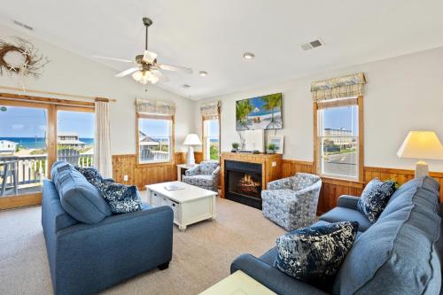 a living room with two blue couches and a fireplace at 6151 - Once Upon a Tide in Nags Head