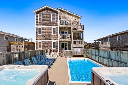 a house with a swimming pool and chairs at 6151 - Once Upon a Tide in Nags Head