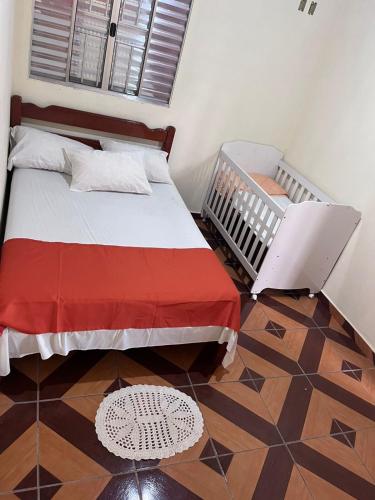 a bedroom with a large bed and a crib at Sítio Santo Expedito in Salesópolis