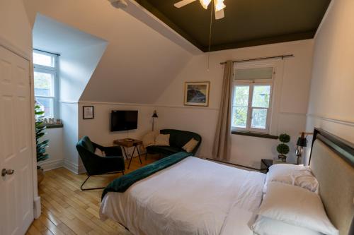 a bedroom with a bed and a living room at Aux petits oiseaux in Baie-Saint-Paul