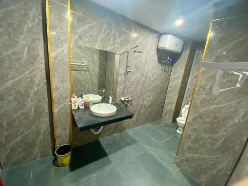 a bathroom with a sink and a shower and a toilet at Khách sạn Tam Sơn in Ha Giang