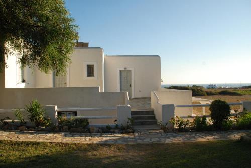a white house with a staircase in front of it at Scala Apartments in Kastraki Naxou